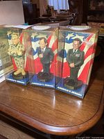 Three boxed America’s Heroes bobbleheads on tabletop