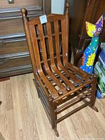 Front view showing slat seat and back, turned posts, overall design