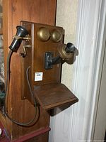 Front view showing wood cabinet, twin brass bells, mouthpiece, receiver and shelf