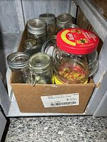 Top view of box showing multiple mason jars, flip-top jar, handled jar with red lid