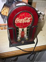 Front view of Coca-Cola radio with illuminated stained glass panel and knobs