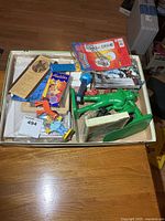 Tray overview showing mixed collectibles, puzzle box, figures, postcards etc.