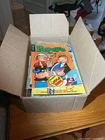 Open box showing stack of comics, Popeye on top