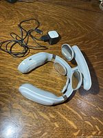 Massager with cable and wall adapter on table