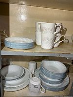 Stacked bowls with blue fluted rim and cups with pink floral pattern