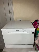 Front view of white Danby countertop dishwasher showing control panel and handle