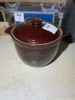 Front view of brown glazed stoneware bean pot with lid