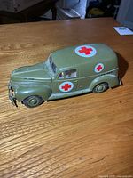 Left side view of olive drab diecast U.S. Army ambulance with red cross decals