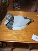 Left side view of carved duck decoy showing coloration and shape