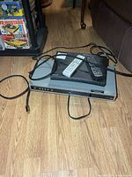 Samsung Blu-ray player on top of silver DVD player with HDMI cable and remotes visible