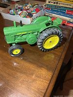 Left side view of green ERTL John Deere Diesel tractor showing engine casting and decals
