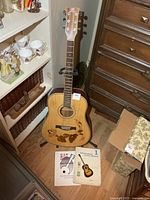 Guitar on stand with two books on floor