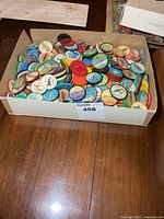 Full cardboard box filled with multicolour plastic Jell-O coins