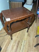 Overall view of wooden side table showing top, legs, magazine rack