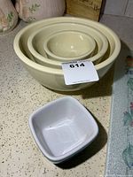 Nested set of three cream stoneware bowls with white square dish