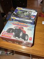 Three boxed model kits stacked; visible Crimson Cruncher and two Grave Digger boxes