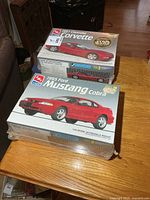 Top view of both sealed model kit boxes stacked: 1997 Corvette on top, 1995 Mustang Cobra bottom