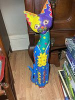 Full view of painted cat sculpture standing on floor