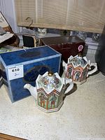 Pair of Sadler teapots with boxes on countertop