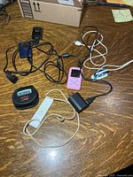 Group shot of iPods, MP3 players, pedometer, charger and cables on table