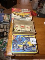 Sealed Mysterion tin with Challenger box and Mustang parts visible