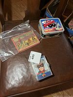 overview showing trading cards case, lunchbox, and bagged handheld game