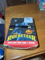 Top view of open Rocketeer trading card display box showing graphics and wear