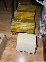 Three tin litho buildings with yellow roofs and box nearby