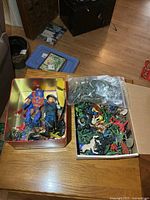 Tin box with two large action figures, various plastic animals