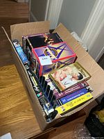 Cardboard box showing a variety of VHS movies with titles partly visible