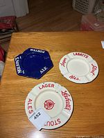 Overview of three enamel ashtrays on table