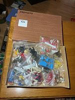 Closed box marked “Premiums” with view of multiple bagged mini toys inside