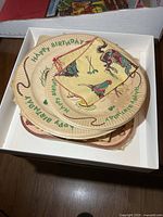 Stack of vintage Davy Crockett paper birthday plates inside box