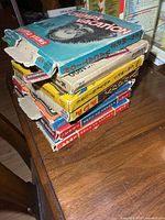 Stack of seven Castle Films boxes with wear, showing various colors and torn edges