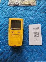 Front view of yellow GasAlert Max XT II detector with info card
