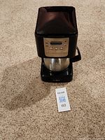 Front view of black Mr. Coffee maker with stainless steel carafe and control panel