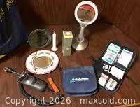 Group shot showing first-aid pouch, two mirrors, electronic device, orange accessory