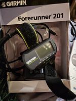 Watch in box showing display, strap, and cables