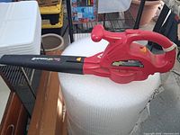 Red/black corded electric 2-speed leaf blower on bubble wrap roll