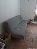 front view of light gray futon showing tufted seat and back