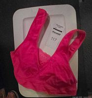 Bright pink racerback sports bra displayed on tray