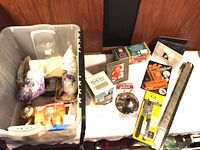 Overview of tote with assorted packaged items and table with boxed Check-GO, steamer basket, frame, tools