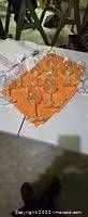 six clear stemmed wine glasses on orange cloth