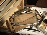 Crate, grease gun, glass visor panel, mirror, partial plastic bin visible