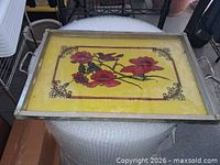 Top view of rectangular metal and glass serving tray with yellow background and red flowers