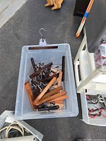 Plastic tote containing assorted wooden clip hangers