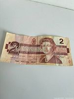Obverse of $2 Canadian banknote showing Queen Elizabeth II portrait and serial EGJ6254790