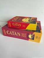 Catan base game box stacked with 5-6 player extension box