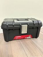 Closed view of black Husky toolbox showing brand label and metal latch