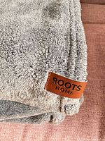Close-up of Roots Home tag stitched to blanket edge
